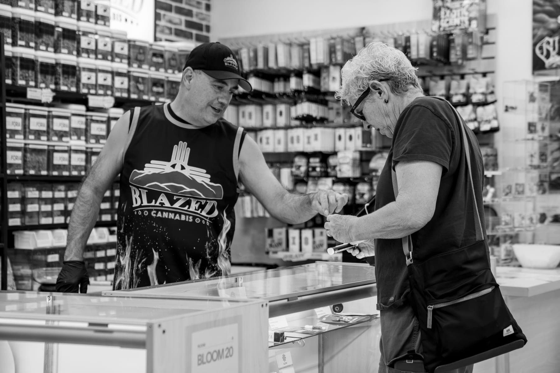 Black-and-white photo of a customer being helped at the deli counter
