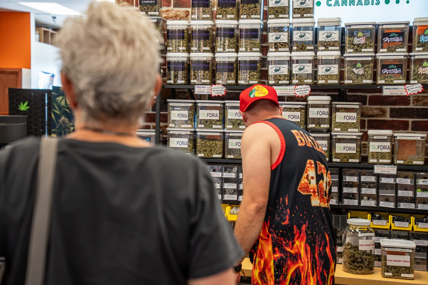 A customer looking over the wall of flower jars with one of the owners