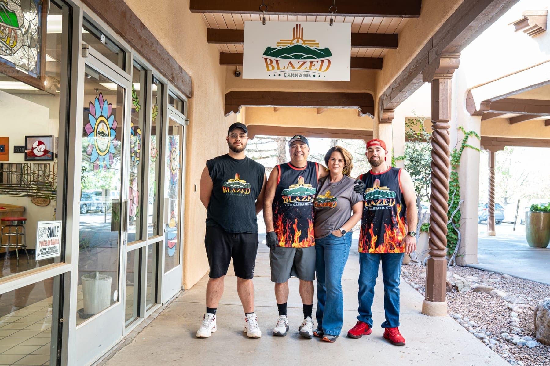 James, Jennifer, Dominic, and Anthony standing together under the portal outside the shop