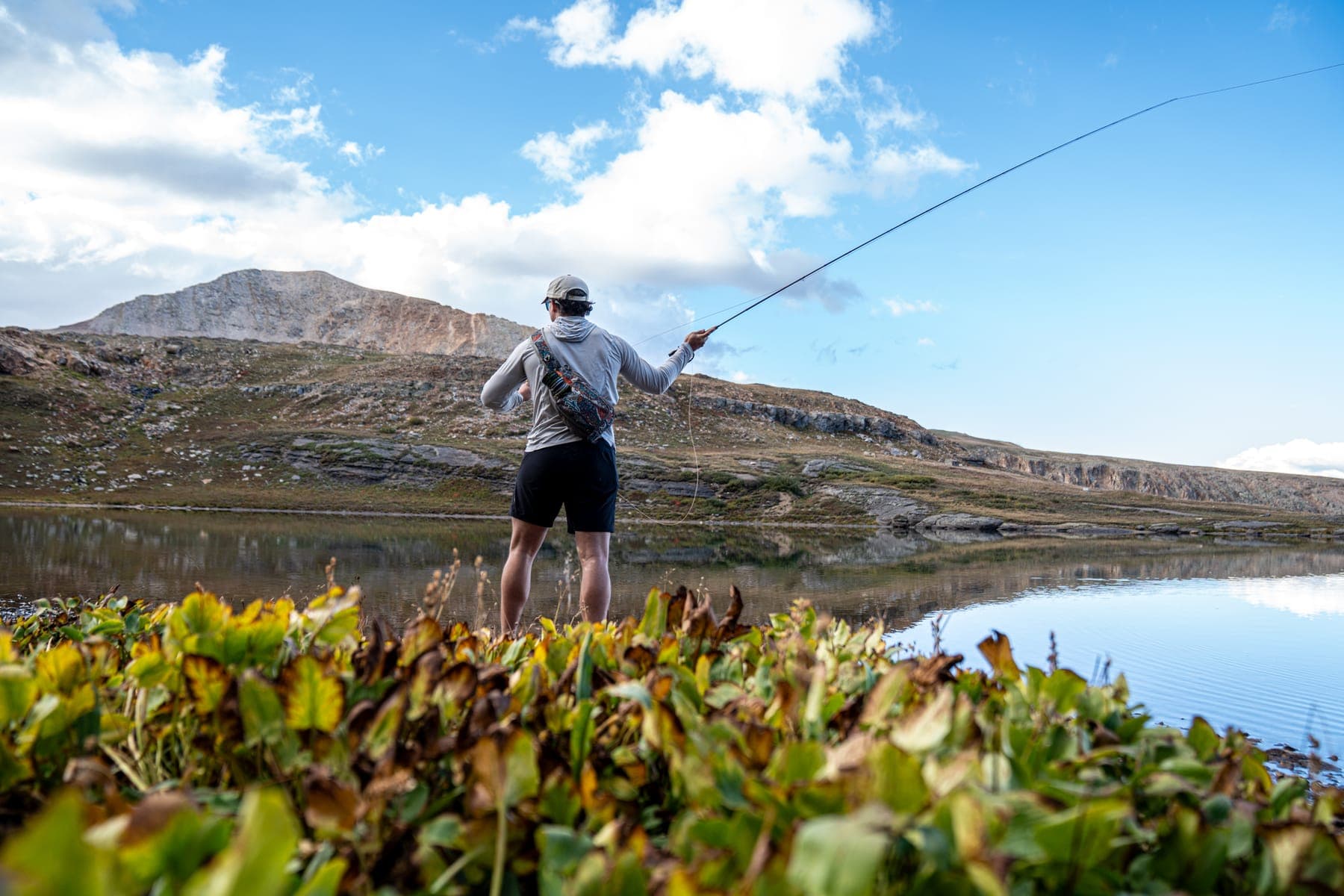 Casting a fly rod at the edge of a high mountain lake