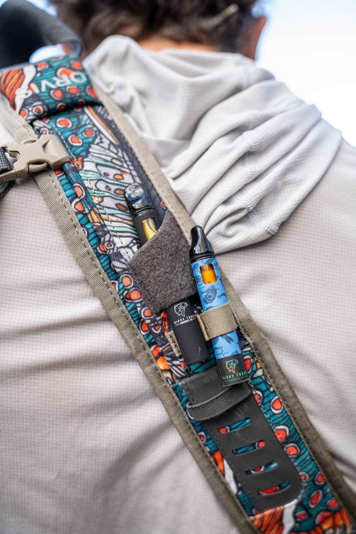 Detail of a fly-fishing pack strap covered in fish-pattern fabric