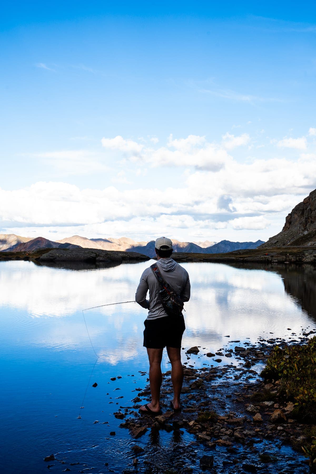 Standing at the shoreline of a deep blue alpine lake