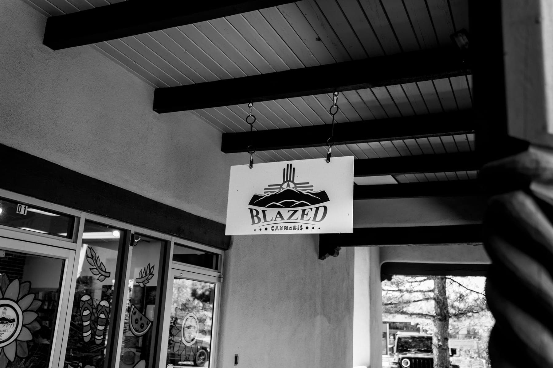 Black-and-white photo of the Blazed Cannabis sign under the portal beams