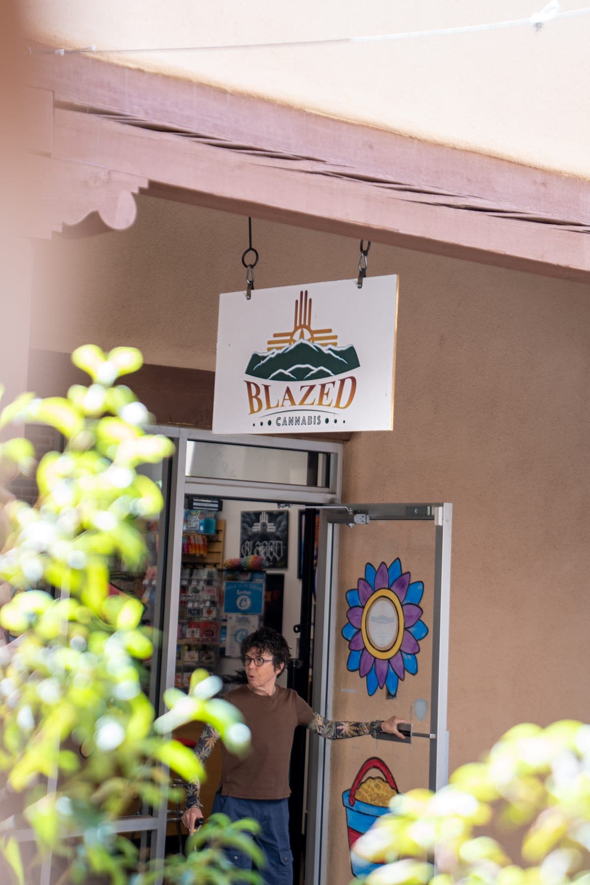 The Blazed Cannabis sign above the shop door, with one of the owners standing in the doorway